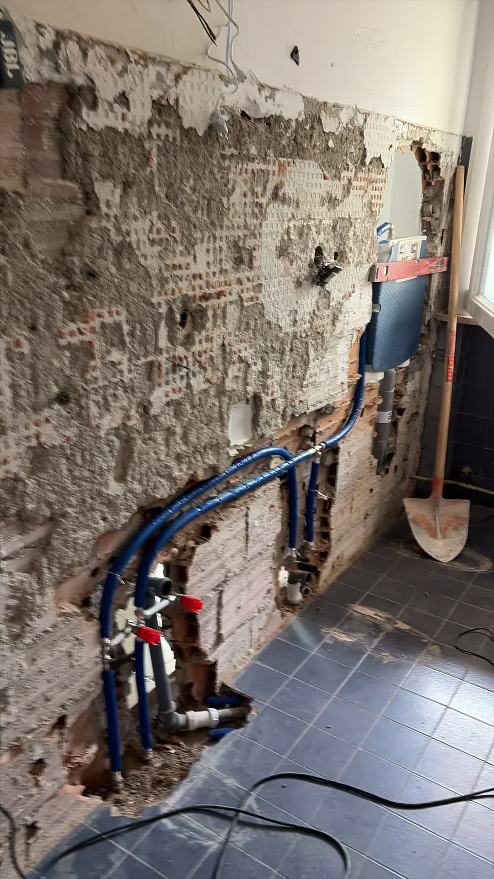 Prima: il bagno demolito fino al mattone, con l'impianto idraulico nuovo già passato