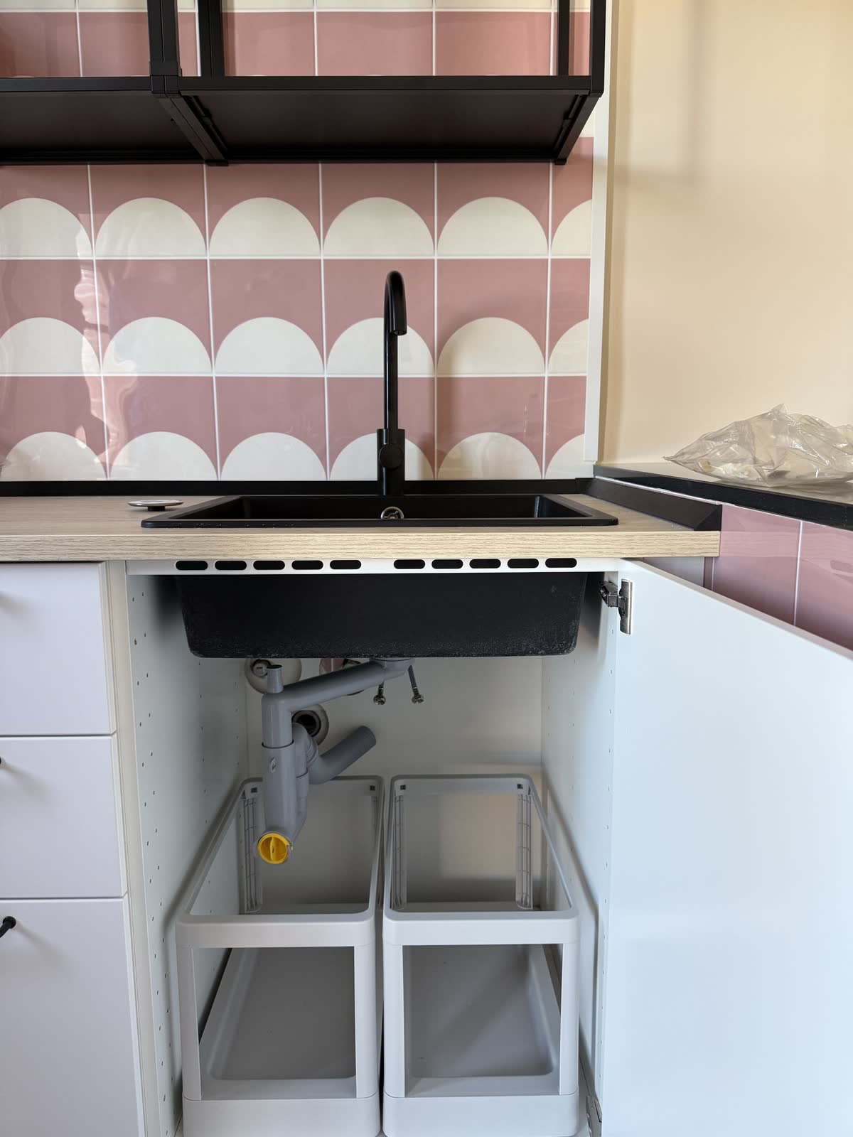 Cucina con lavello nero e nuovo scarico montato sotto il piano